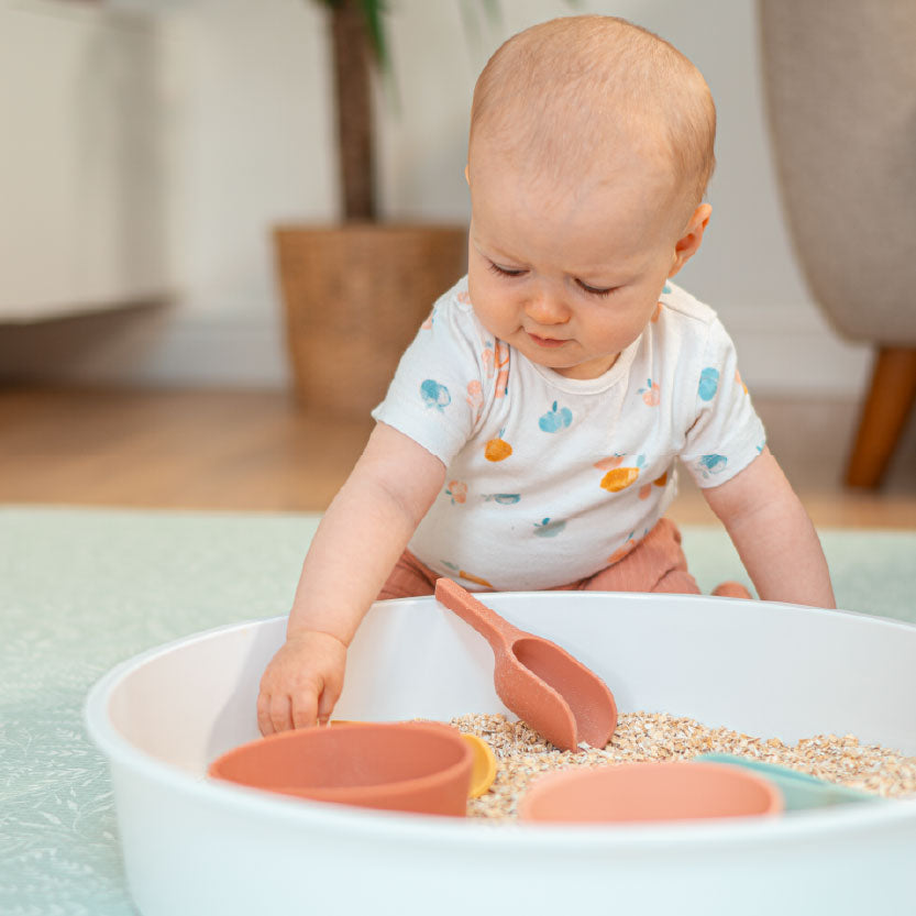 baby playing with oats in PlayTRAY