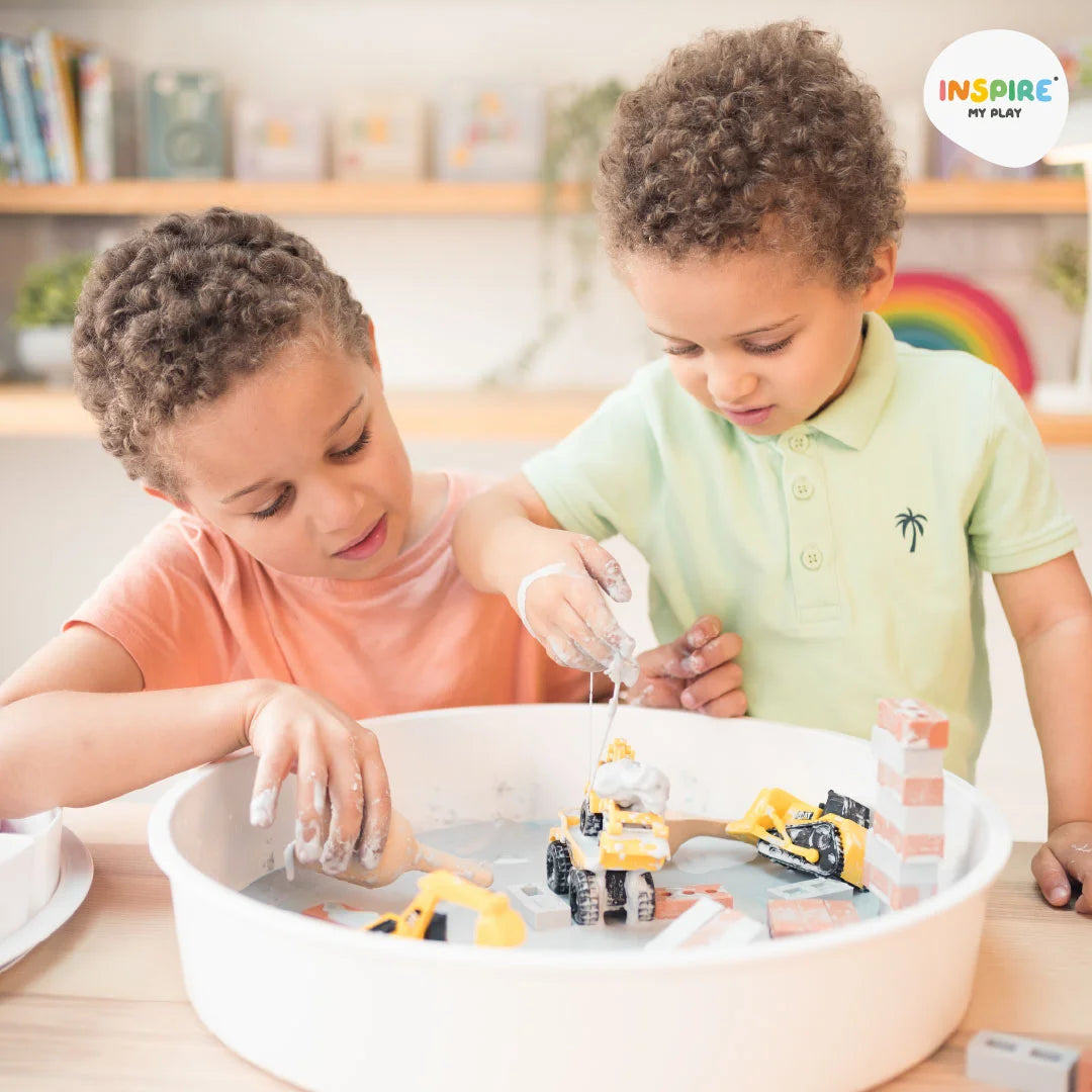 Two boys playing with oobleck, bricks and diggers in a PlayTRAY 