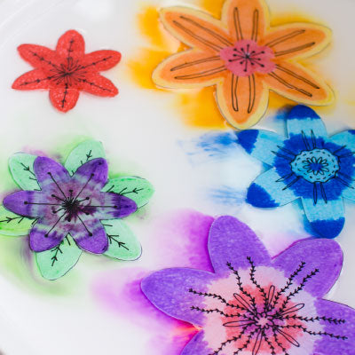 colourful paper flowers blooming in water 