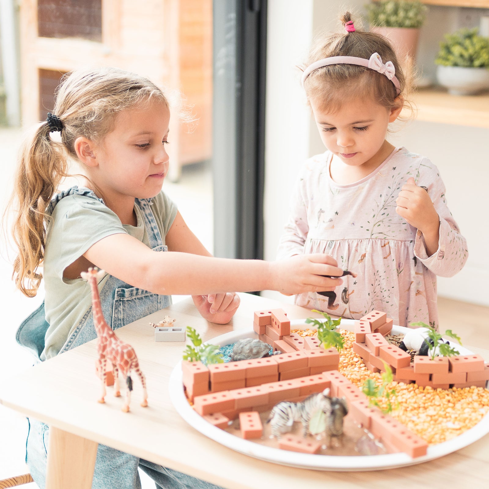 Two children playing with small world zoo in playTRAY 