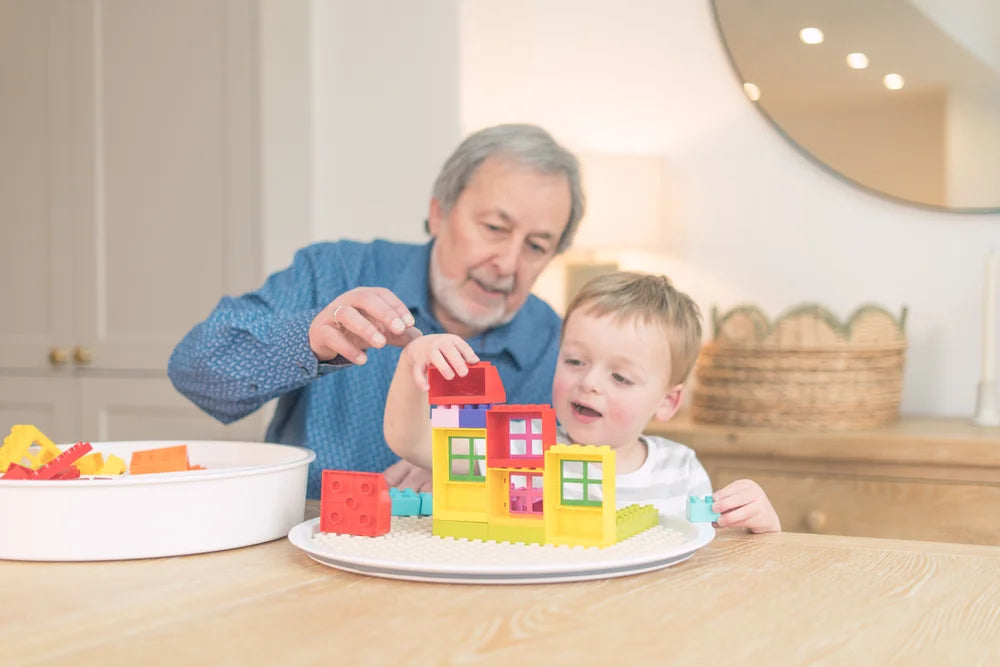 Grandfather and grandchild playing with DUPLO on the Inspire My Play building block mat