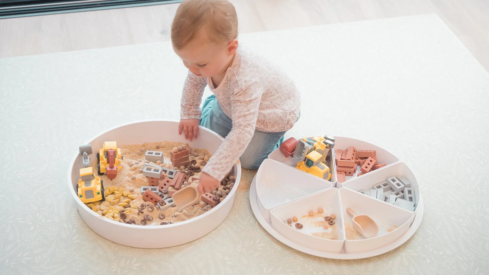 Baby playing with a scoop in the PlayTRAY
