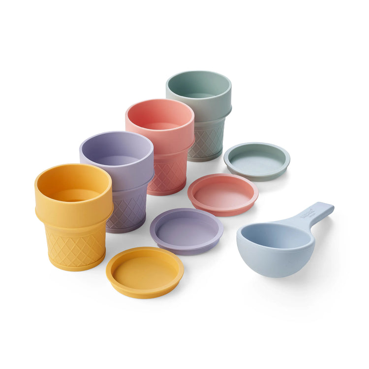 A children's ice cream play set with pastel-coloured silicone ice cream cones, matching lids and a blue ice cream scoop arranged on a clean white background.