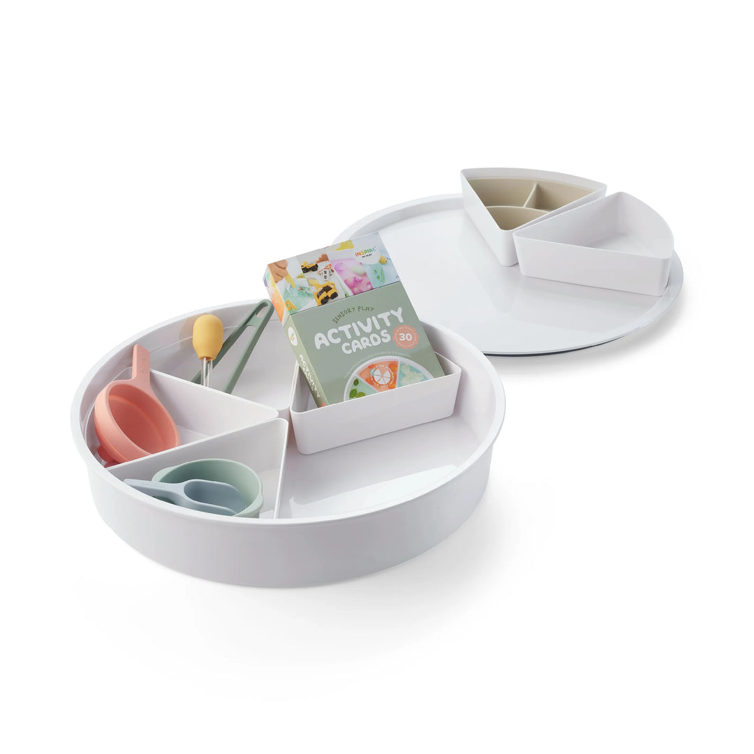 A children's sensory bin for sensory play with matching lid filled with silicone sensory play tools including a nesting bowl, funnel, scoop, dropper and pair of tongs, organiser and box of sensory play activity cards on a clean white background.