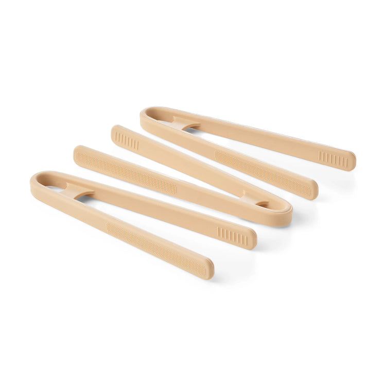 Three pairs of silicone sensory play tongs in natural beige shades, arranged diagonally on a white background.