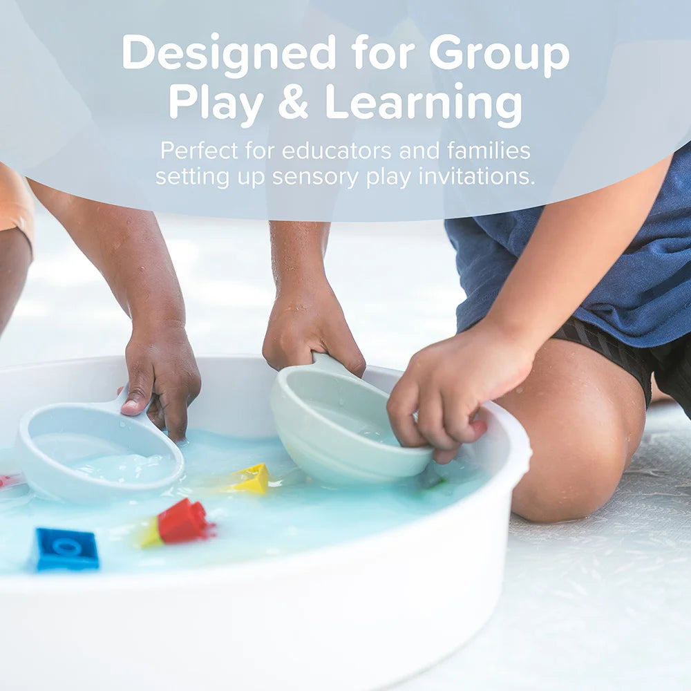 Children playing with sensory play funnels and blocks in the Inspire My Play sensory bin, designed for group play and learning.