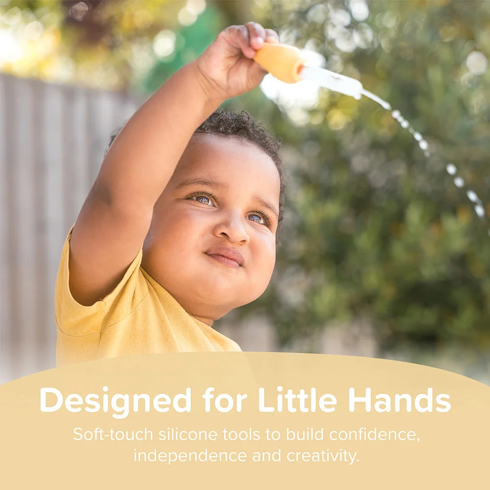 Child holding a soft-touch sensory play silicone dropper with water to help build confidence, creativity and independence.