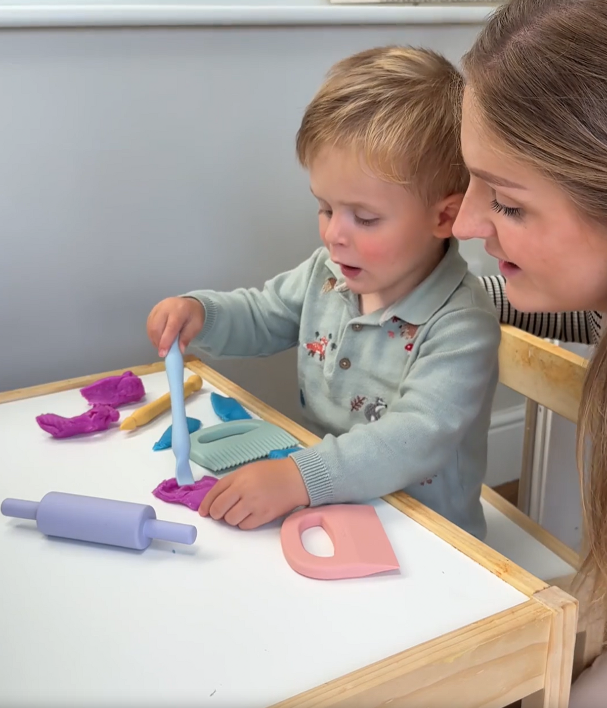 Child playing with playdough and colourful silicone playdough tools for sensory play.
