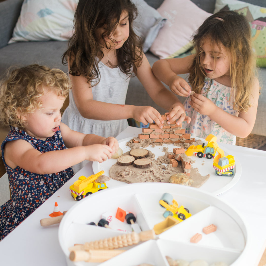 Children playing together with construction themed materials and objects